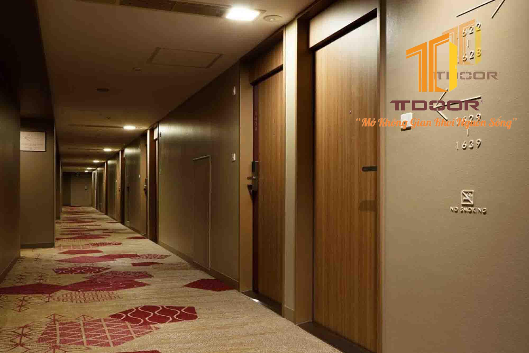 Cửa gỗ màu ấm phù hợp với hàng lang khách sạn có gam màu ấm